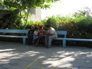 February 25: A tutor working with Balta while others look on.